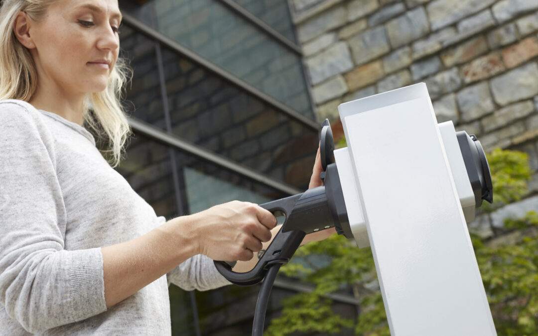 Mitarbeiterin lädt Elektro-Auto