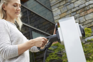 Mitarbeiterin lädt Elektro-Auto